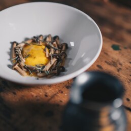 a white bowl filled with food on top of a wooden table